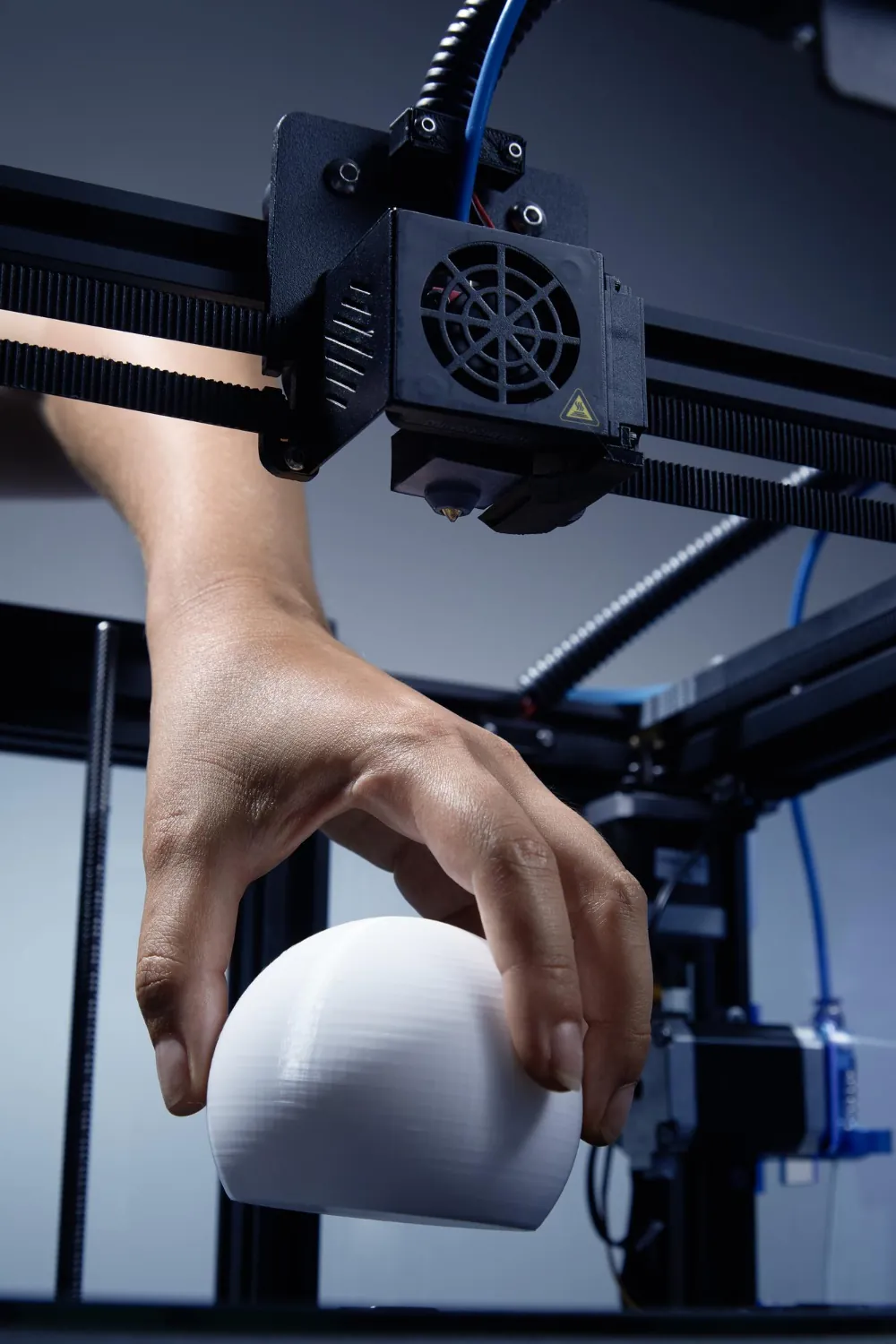 A freshly manufactured 3D printed piece being removed from a printer
